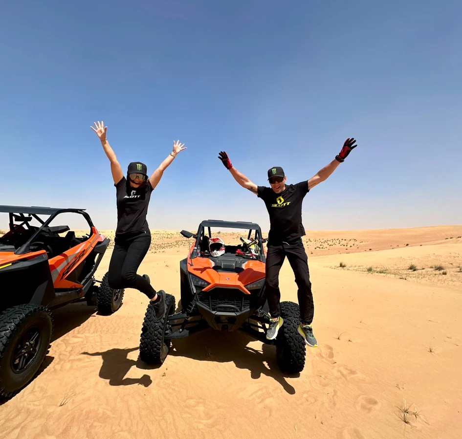 Couple jump off the wheels of dune buggy while on a Buggy Tour experience with SAZ Dubai